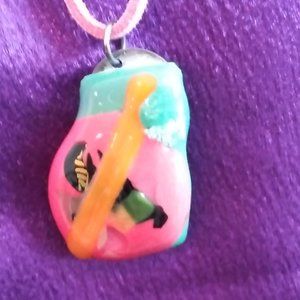 Handcrafted fused glass pendant. Mainly a pink with other accents. Has an 80s lo